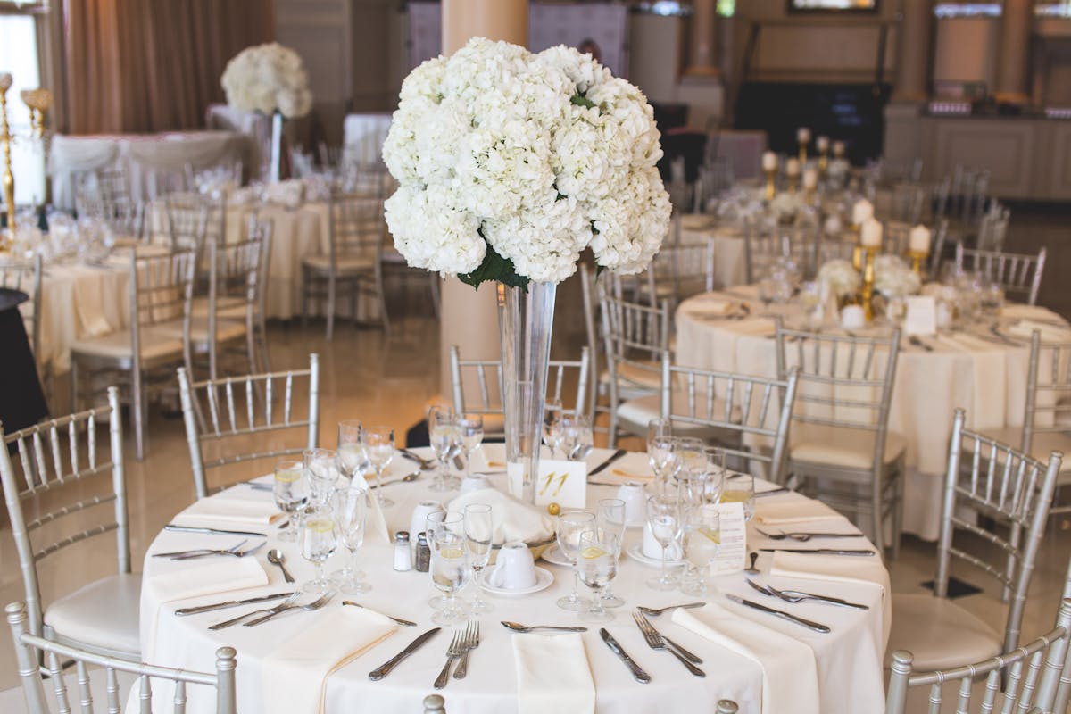 What are the elements that define an all white wedding_off white wedding table setting with whote flowers