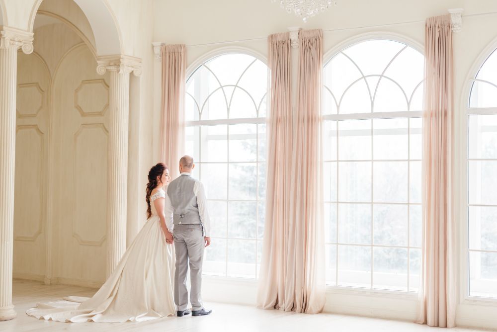 Victorian-wedding-couple-posing-in-an-elegant-room-full-of-light