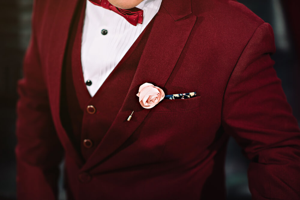 Red and gold traditional wedding attire - groom, red clothes, pink rose