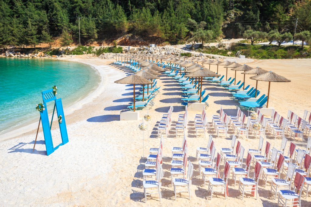 Rose gold theme wedding - beach, white chairs, sand, trees